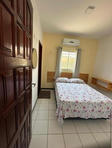 a bedroom with a bed and a window and a door at Apartamento Amarelinho - Canoa Quebrada in Aracati
