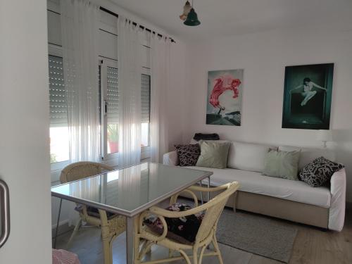 ein Wohnzimmer mit einem Glastisch und einer Couch in der Unterkunft Suite de invitados independiente in Cerdanyola del Valles