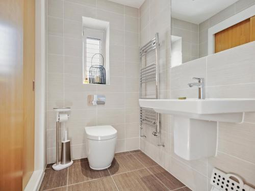 ein weißes Badezimmer mit Toilette und Waschbecken in der Unterkunft Knighton - Luxury Dorset lakeside home, sleeps 12 with spa and pool access in Warmwell