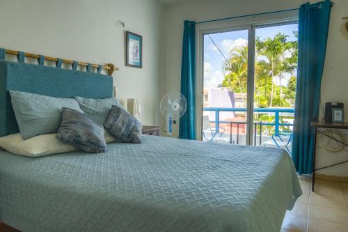 a bedroom with a bed with a view of a balcony at CASA MINERVA MERIDA in Mérida