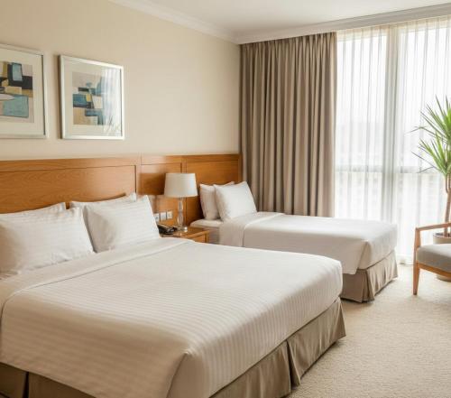 una camera d'albergo con due letti e una finestra di Zafer Hotel a Malatya