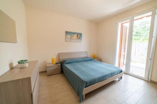 a bedroom with a bed and a large window at Golfo di Lacona in Lacona