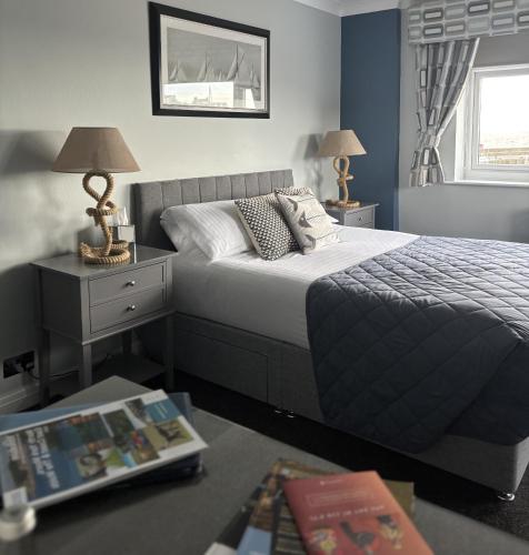 a bedroom with a bed and a table with lamps at Salt on the Harbour in Bridlington