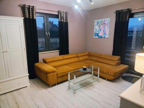 a living room with a couch and a table at Apartament na Chmielnej in Rychwał