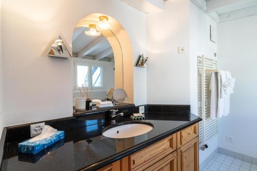 een badkamer met een wastafel en een spiegel bij Edelweiss Schlosswohnung in Flims