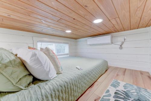 Posto letto in una piccola camera con soffitto in legno. di Tiny Islands Resort - Kauai a Fischer