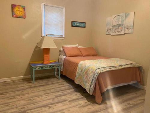 una camera da letto con un letto e un tavolo con una lampada di Fun Beach House With Pool Alligator Point a Sun N Sand Beaches