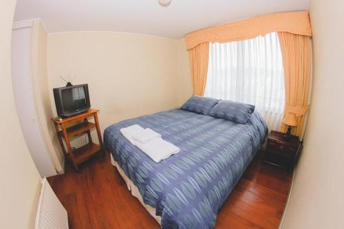 Dormitorio pequeño con cama y TV en Departamento Don Matias Lincoyan, en Concepción