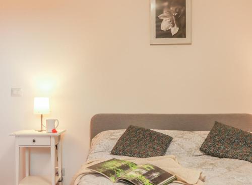 een slaapkamer met een bed en een tafel met een lamp bij Casa Lukezovi 