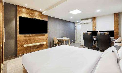 una stanza con un letto, un tavolo e una tv di Hotel Pacific a Suwon