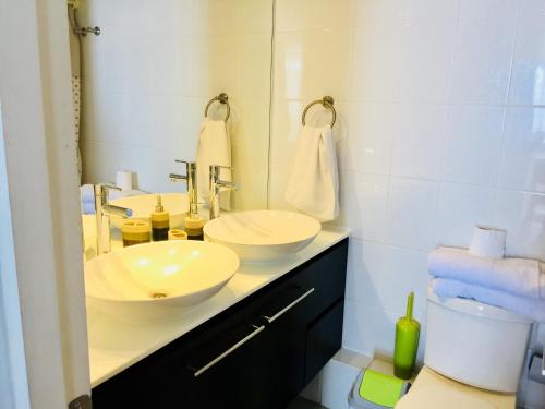 een badkamer met een wastafel en een spiegel bij Arriendo Iquique frente a Playa Brava in Iquique
