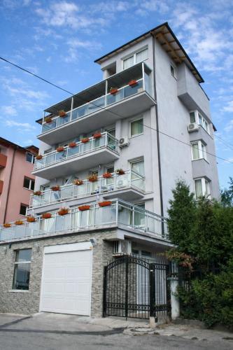 a tall white building with a white garage door at Hotel Villa Harmony - Panoramic View & Free Parking in Sarajevo