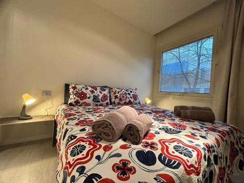 a bedroom with a bed with a flowered blanket and a window at CARPI SUITE - Appartamenti Minghetti in Carpi