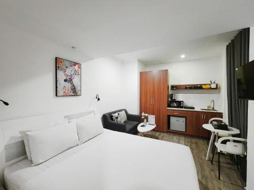 a hotel room with a white bed and a chair at ZODY Boutique Hotel in Ho Chi Minh City