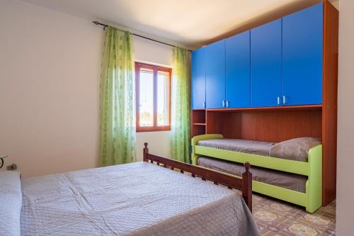 a bedroom with two beds and blue cabinets at Villa Antonina & Mino in Cala Liberotto