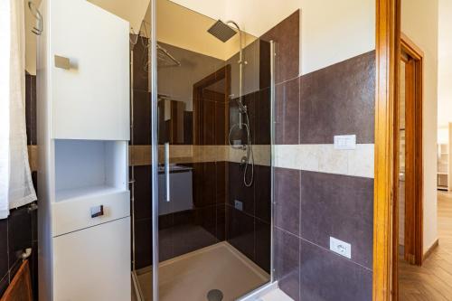 a shower with a glass door in a bathroom at Villa Antonina & Mino in Cala Liberotto