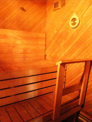 a wooden sauna with a wooden bench in a room at Home for Guests Lakštingala in Šiauliai