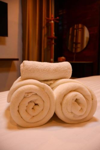 a pile of rolled towels sitting on a bed at ANNKAMii INN in Pai