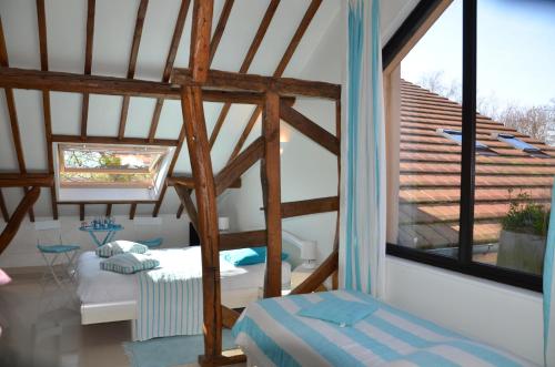 a attic room with a bed and a large window at La Villa Antalya in Ault