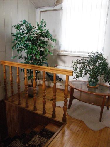 a wooden staircase with two potted plants and a table at Home for Guests Lakštingala in Šiauliai