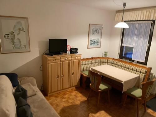 un salon avec une table et un canapé dans l'établissement Ferienwohnung Sonnenring, à Heide