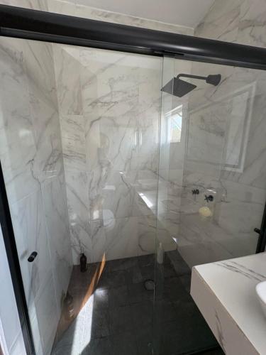 a shower with a glass door in a bathroom at La casa blanca in Mezcales