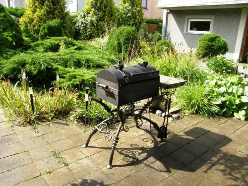 a grill sitting in the middle of a garden at Home for Guests Lakštingala in Šiauliai