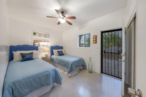 a bedroom with two beds and a ceiling fan at 24th St (Deepak & Jackie) in Tucson