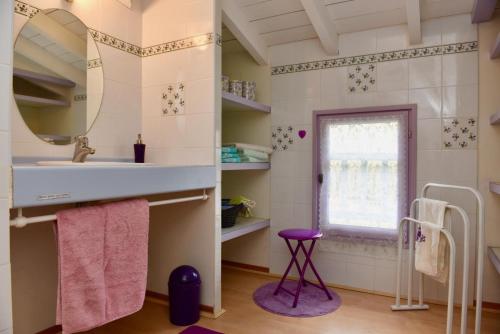 een badkamer met een wastafel, een spiegel en een raam bij La cheneraie in Mano