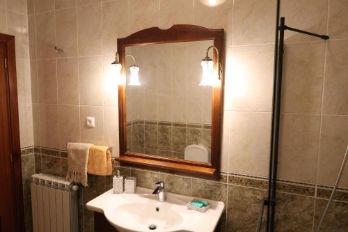 a bathroom with a sink and a mirror and a shower at Qt Refúgio de Rubiães Villa 1-2 Paredes de Coura in Paredes de Coura
