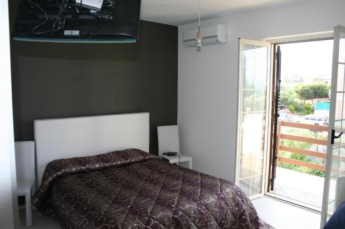 アマンテーアにあるAppartamento Fortunaのベッドルーム1室(ベッド1台付)、スライド式ガラスドアが備わります。