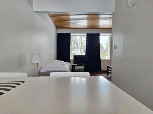 a bedroom with a bed and a window and a table at Spacious Apartment for 5 in Sodankylä