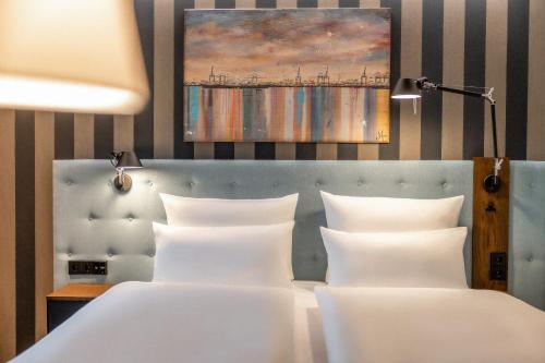 een slaapkamer met twee bedden en een schilderij aan de muur bij The Cloud One Frankfurt - Metropolitan in Frankfurt am Main