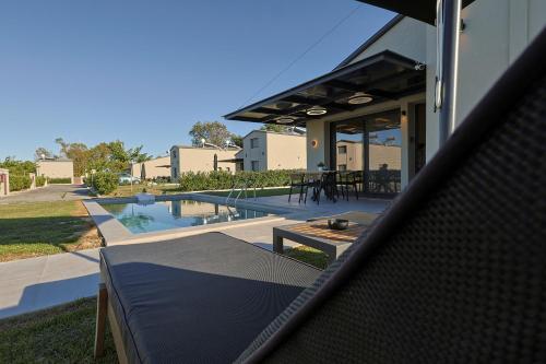 una casa con patio e piscina di HELIOS - Seaside Pool Villa & Private Parking a Olympiakí Aktí