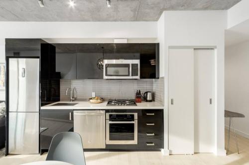a kitchen with stainless steel appliances and a microwave at Spacious and Stylish Modern Condo in Calgary in Calgary