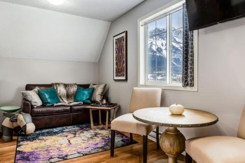 a living room with a couch and a table at Cozy getaway for exploring Canmore and Banff in Canmore