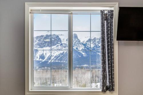 a window with a view of a mountain at Cozy getaway for exploring Canmore and Banff in Canmore