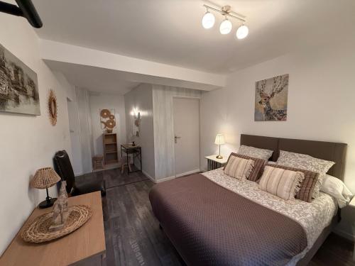 ein Schlafzimmer mit einem großen Bett und einem Tisch in der Unterkunft Douce Campagne in Le Pouzin