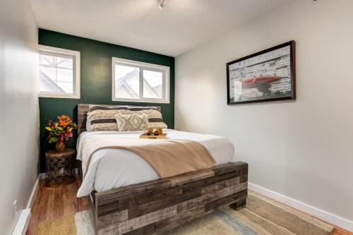 a bedroom with a bed and two windows at Delightful 2BR Mountain Escape in Canmore in Canmore
