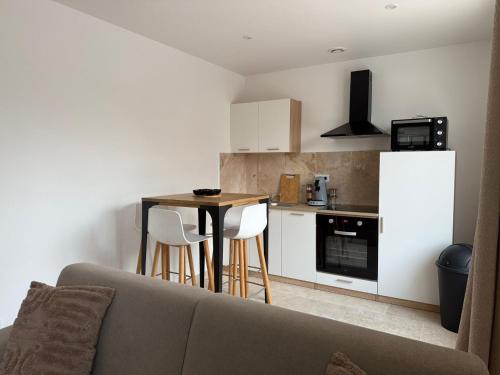 ein Wohnzimmer mit einem Sofa und einer kleinen Küche in der Unterkunft Le prestige - Charmant T2 neuf avec Terrasse in Évreux