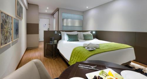 una habitación de hotel con una cama grande y una mesa en Comfort Suites Flamboyant Goiânia en Goiânia