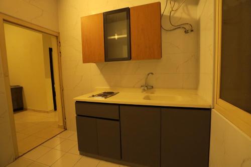 una piccola cucina con lavandino e armadietto di منازل الحساء للشقق الفندقية a Al Hofuf