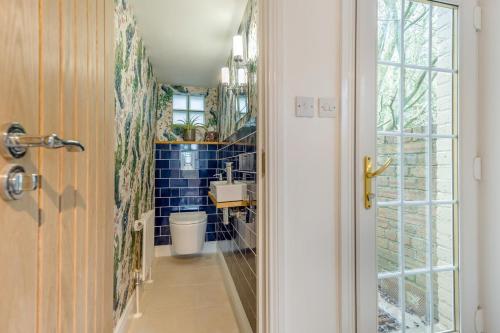 ein Badezimmer mit Waschbecken und einem blau gefliesten Flur in der Unterkunft 3 Bed in Melkridge oc-b33370 in Haltwhistle