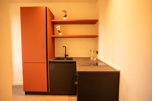 a kitchen with an orange cabinet and a sink at Sicilias in Catania