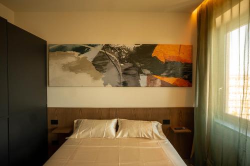 a bedroom with a bed and a painting on the wall at Sicilias in Catania