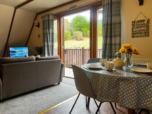 a living room with a table and a couch at Ericht Holiday Lodges in Blairgowrie