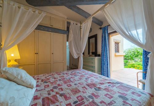 1 Schlafzimmer mit einem Bett mit Vorhängen und einer Küche in der Unterkunft Villa Domo Mea - by Searly in Porto Cervo