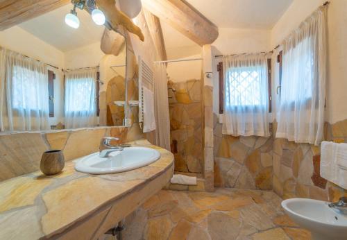 ein großes Badezimmer mit zwei Waschbecken und einem großen Spiegel in der Unterkunft Villa Domo Mea - by Searly in Porto Cervo
