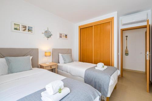 two beds in a room with two towels on them at Cabanas Beach T2 in Cabanas de Tavira