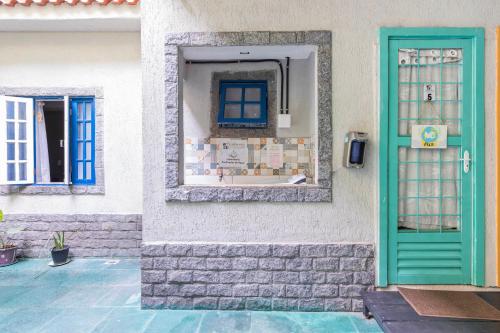 una casa con una porta verde e una finestra di Studio Romântico a Volta Redonda